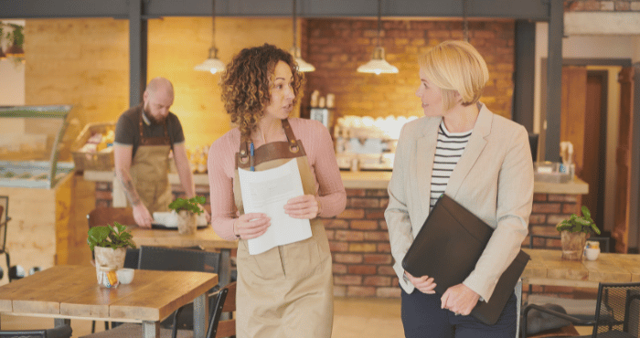 Small business owner talking with a businesswoman in her store