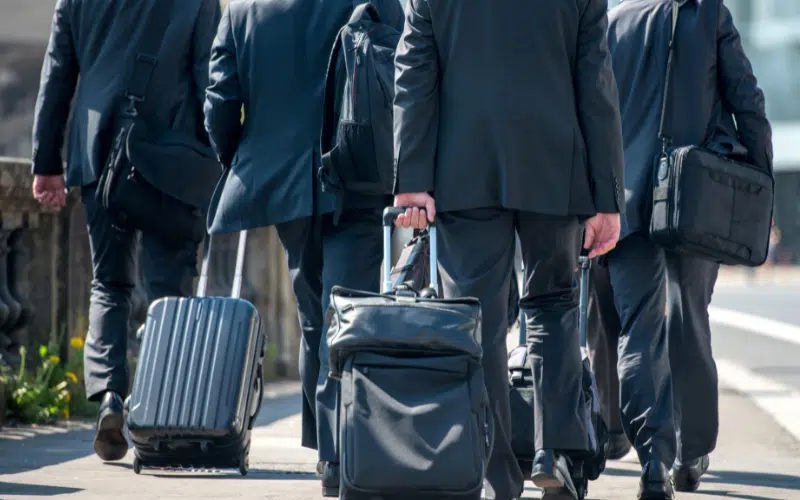 A group of businessmen pulling suitcases with luggage