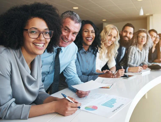 Équipe souriante à un long bureau