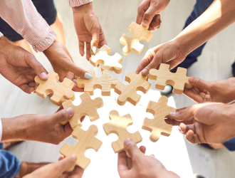 Hands holding block puzzle pieces together