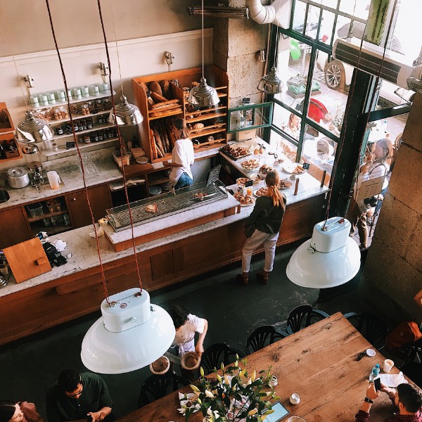 Image shows a restaurant/café with its owner, employees and customers