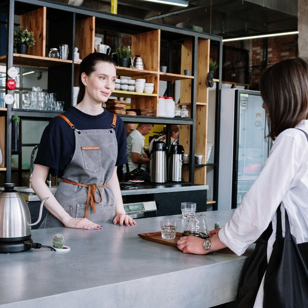 A small business owner talking with one of her employees in her café