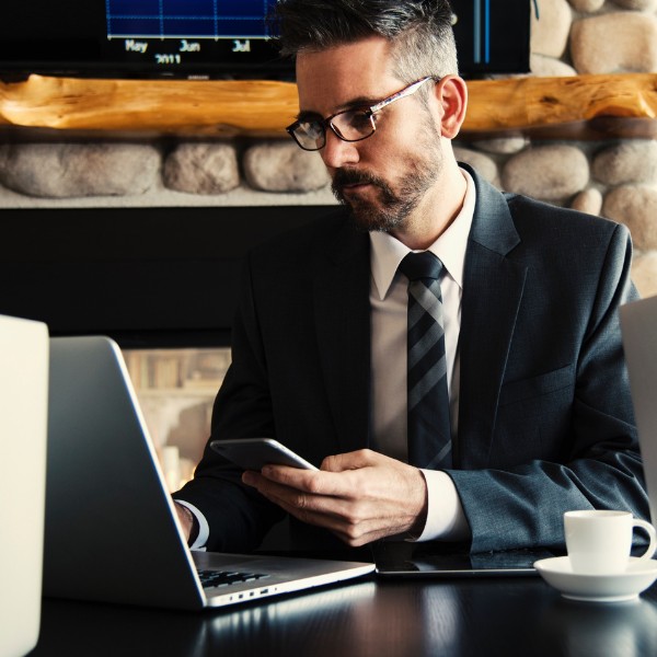 Propriétaire de petite entreprise en train de regarder son téléphone et ordinateur portables