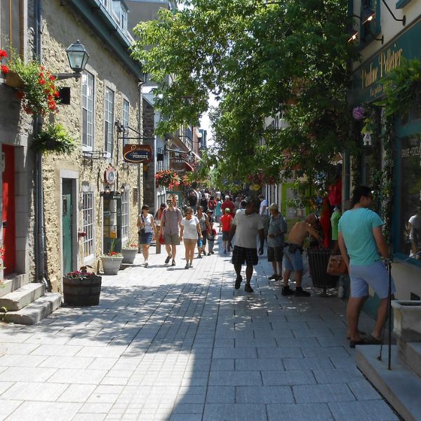 People walking down Quebec street lined with small businesses