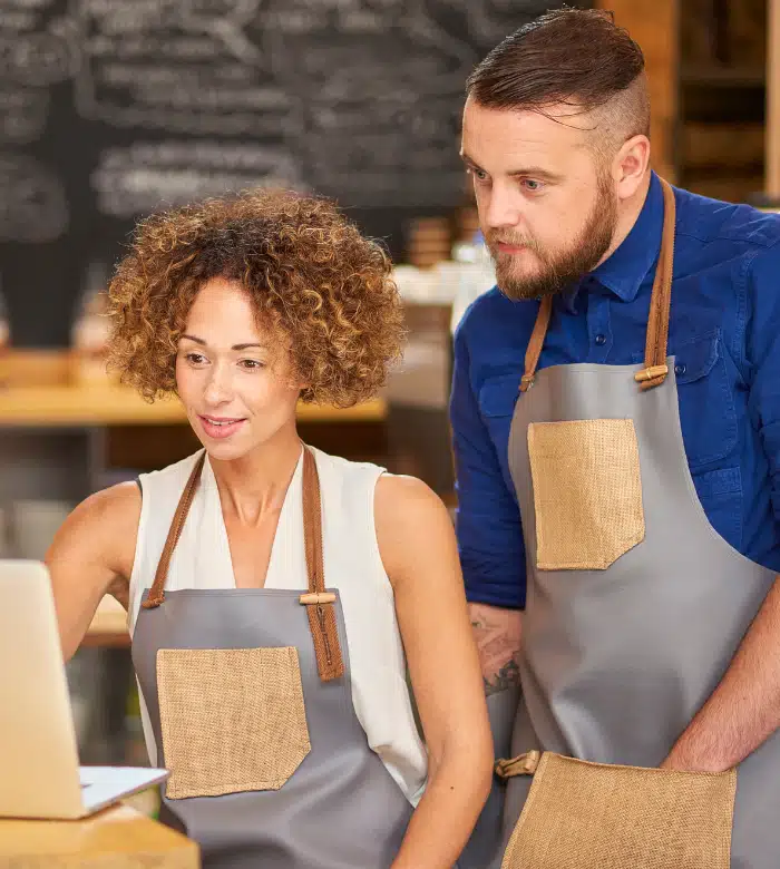 A small business owner with one of her employees in Alberta looking at their laptop