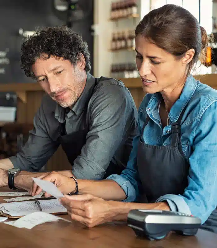 Two small business owners checking costs, bills and receipts