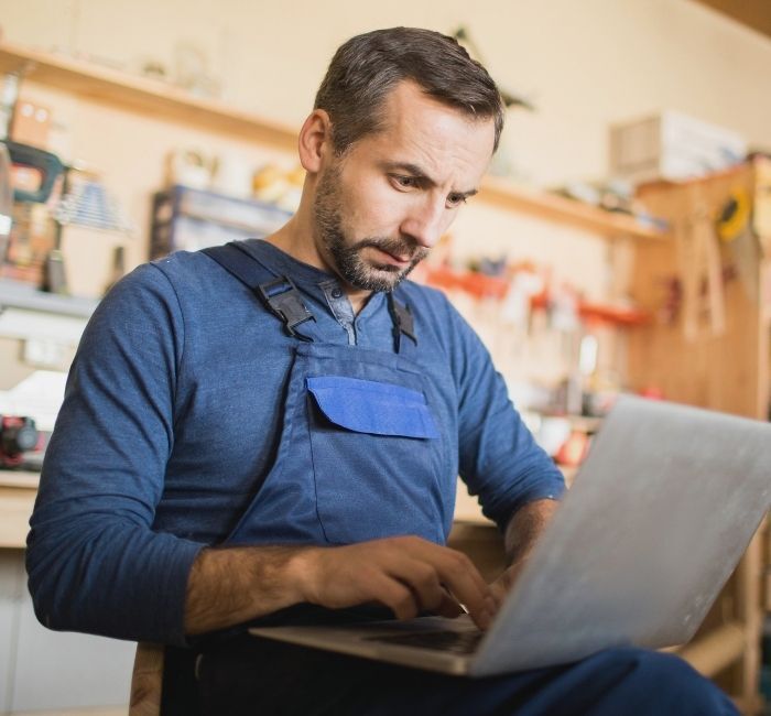 Small business owner working on a laptop in a workshop