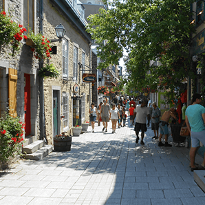 People walking down Quebec street lined with small businesses