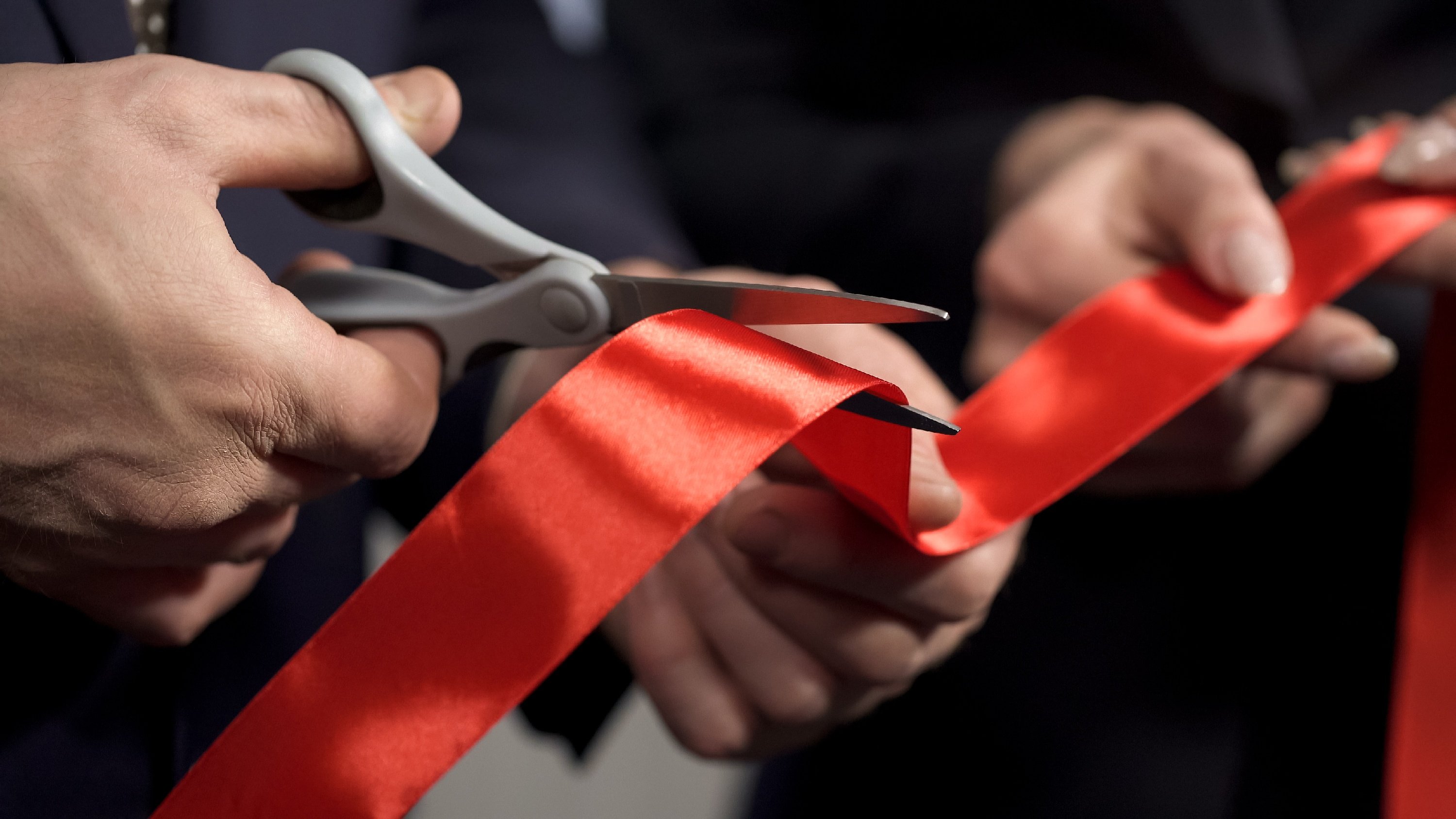 Red tape being cut with scissors