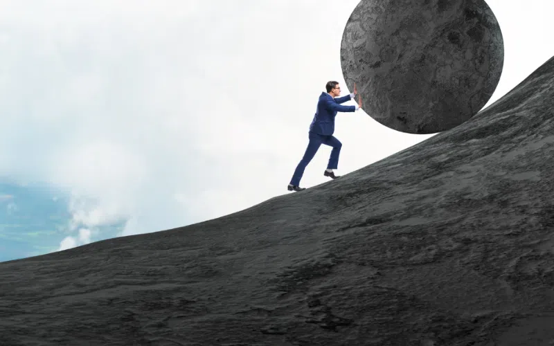Small business owner pushing a stone symbolizing the weight of payroll tax on small business owners in general