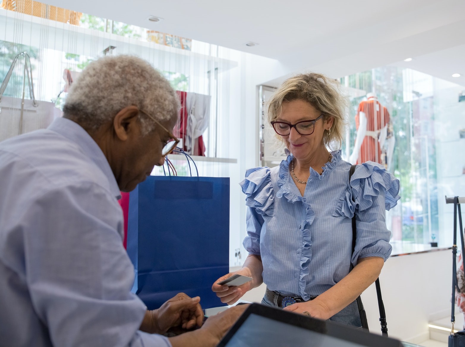 Small business owner helping a customer pay for her purchases by credit card