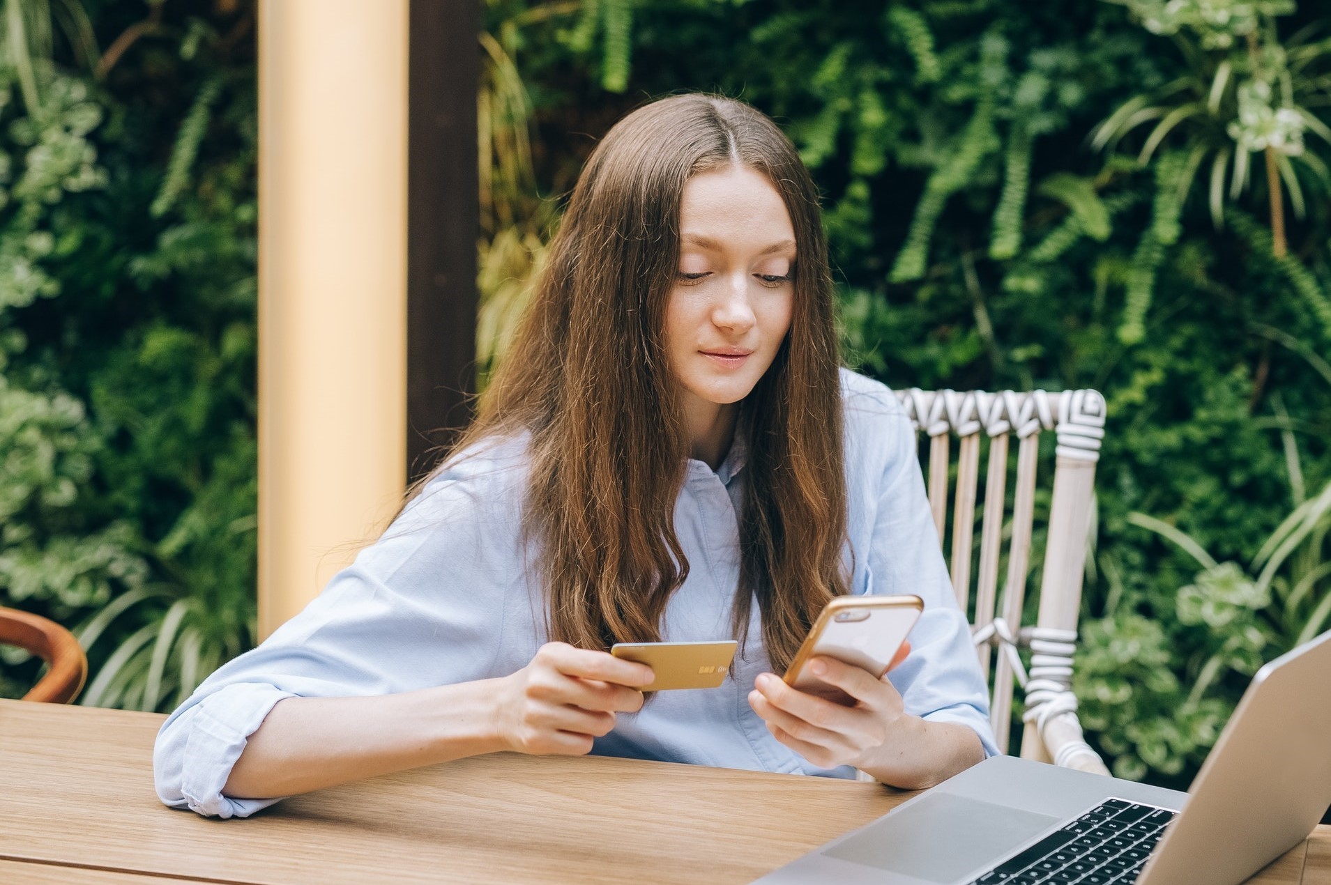 Small business owner looking at her credit card and cellphone