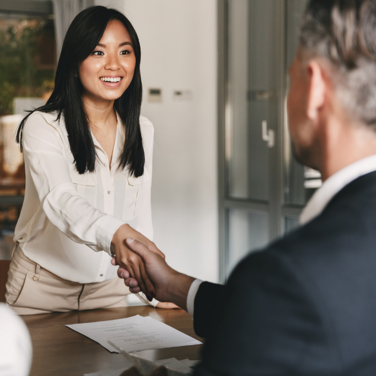 A lady shaking hands with a man both professionally dressed. 