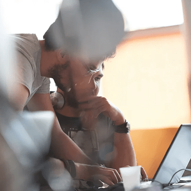 Two colleagues looking at a computer and working together