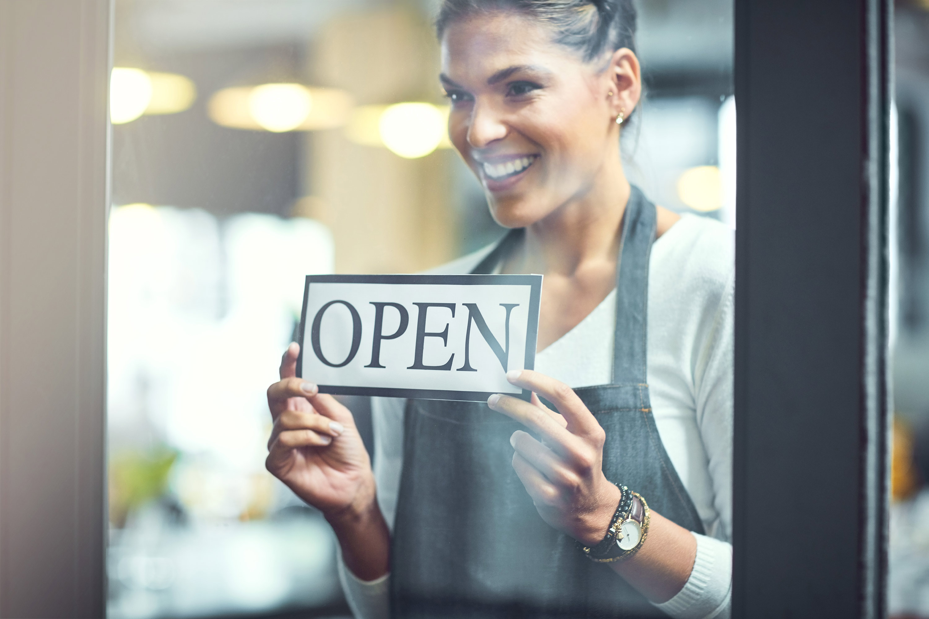 Woman holding an open sign